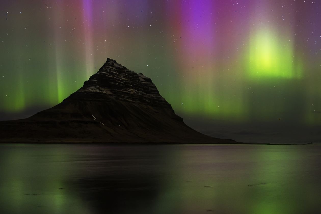 Northern lights dancing over Kirkjufell mountain in Iceland